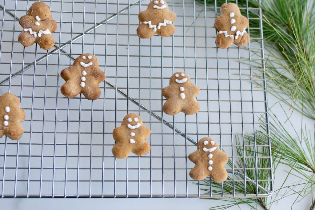 decorated gingerbread dog cookies lay to cool on a wire rack.