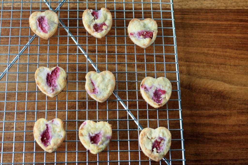 strawberry Valentine's Day dog treats lay to cool on a wire rack