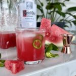 A sparkling watermelon vodka cocktail is in a chilled glass on a counter with Ketel One Vodka, watermelon juice and watermelon