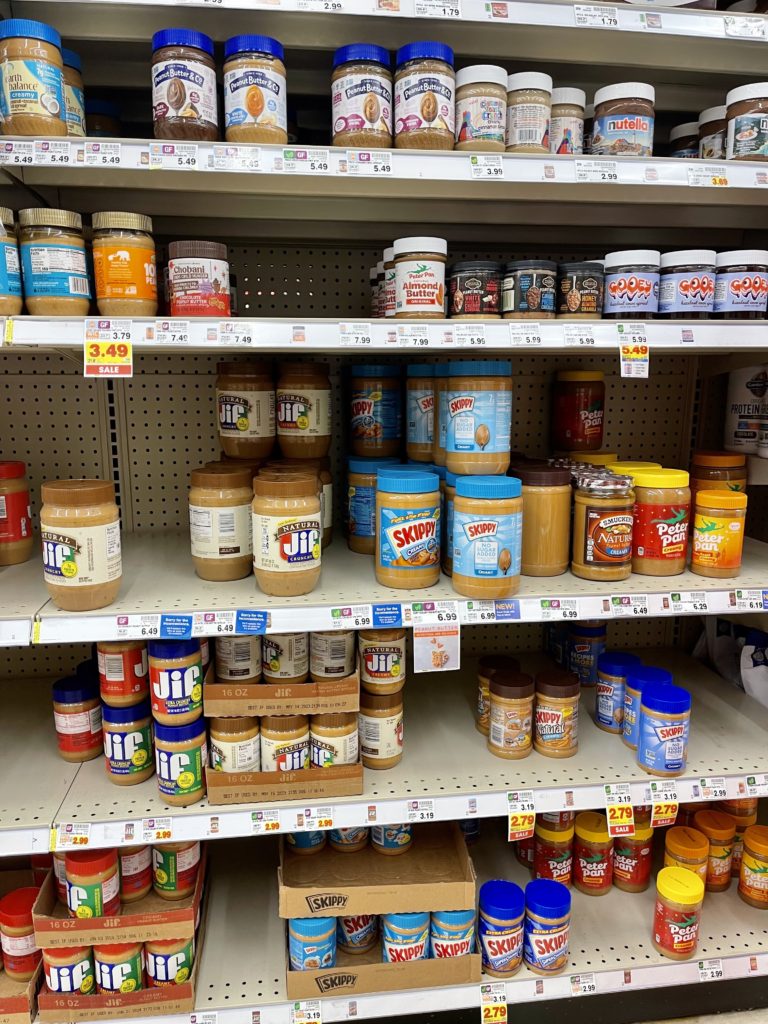 many Peanut butter brands found in the aisle of a Kroger store