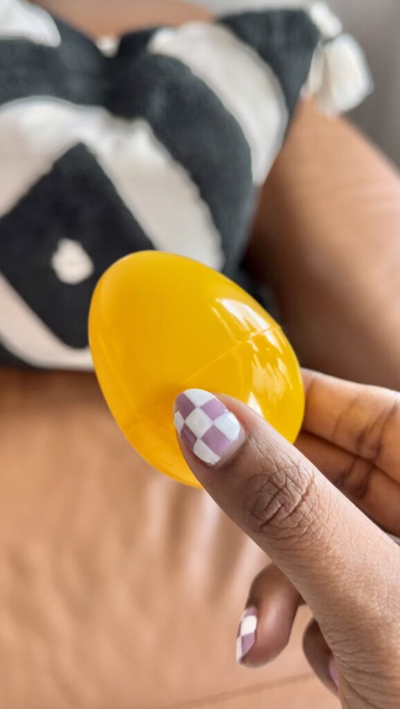 A women holds a plastic yellow Easter egg