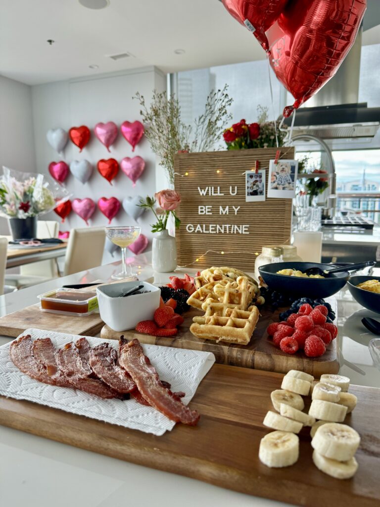 galentine's day brunch with waffles, fresh berries, bacon and eggs. board states will you be my galentine?