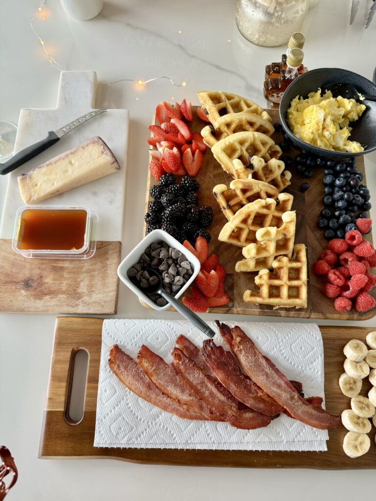 breakfast chacuterie board with waffle bar, fresh fruit, eggs and bacon
