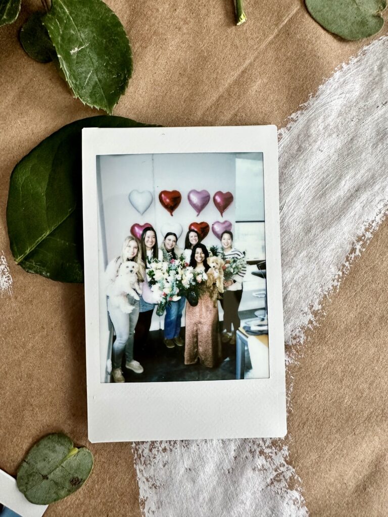 polaroid of dog moms holding the flower arrangements they created